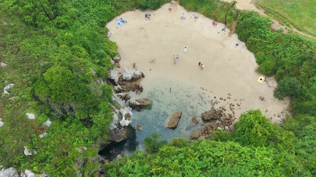Aerial View of the Unique Inland Tidal Beach of Playa de Gulpiyuri Surrounded by Green Cliffs and Meadows in Asturias, Northern Spain