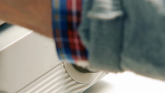 Detail View of Person Turning Control Knob on Microfilm Machine - 4K