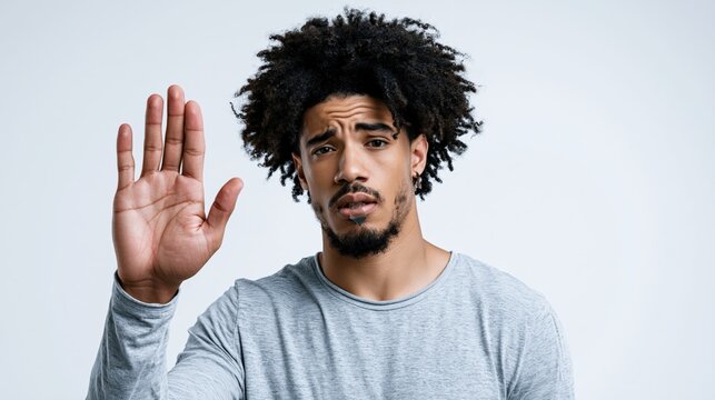 Man holds hand up to signal stop or disagreement.