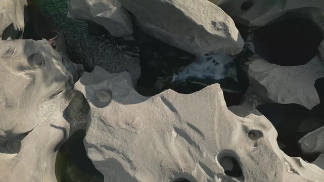Sculpted quartzite potholes carved by the Sao Miguel River at Vale da Lua, Chapada dos Veadeiros National Park, Alto Paraiso de Goias, Brazil, top down drone forward flyover.