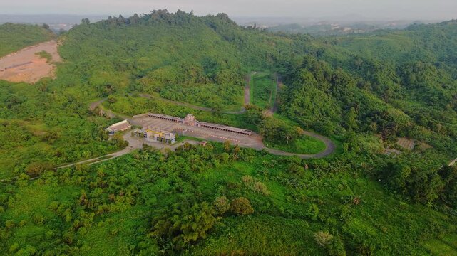 Aerial view of Kalan Circuit surrounded by lush green hills and dense tropical vegetation in Samarinda, East Kalimantan, Indonesia.