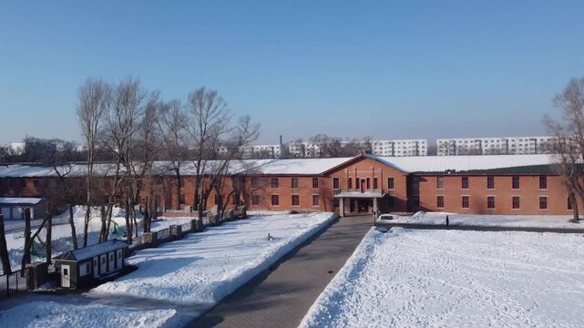 Aerial view of the historic red brick buildings at the Site of Unit 731 museum covered in winter snow in Harbin, Heilongjiang, China.