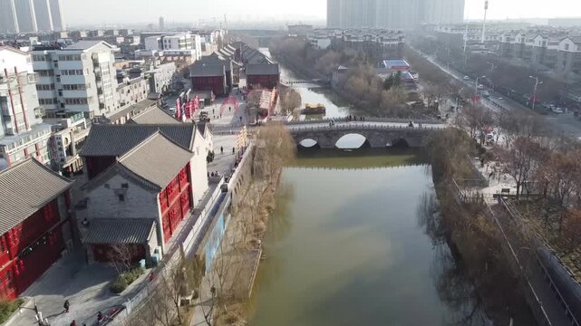 Aerial view of the historic Lijingmen gate and traditional architecture along the river in the old town of Luoyang, Henan, China.
