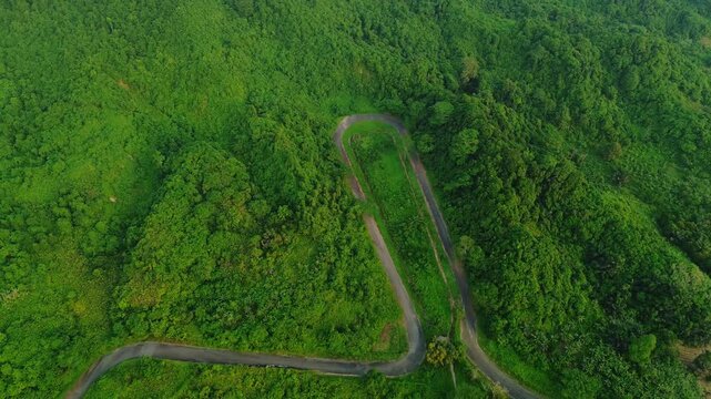 Aerial view of Kalan Circuit winding through dense green forest in Samarinda, East Kalimantan, Indonesia.