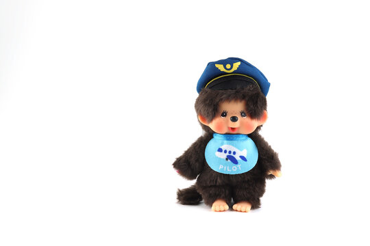 popular monkey classic doll toy , Monchichi or Monchhichi , Japanese cute pilot costume monkey fur doll display on white table with white wall background in souvenir tourist shop in Japan art toy