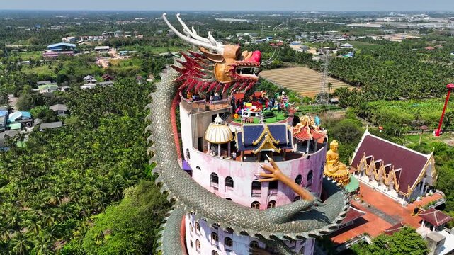Aerial view of the iconic dragon-wrapped Wat Sam Phran temple with its unique architecture and lush surroundings in Sam Phran, Nakhon Pathom, Thailand.