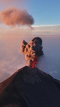 Aerial view of Volcan de Fuego erupting with ash plume rising into the sky at sunset in Yepocapa, Chimaltenango Department, Guatemala.