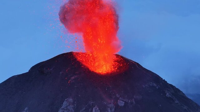 Aerial view of Volcan de Fuego erupting with glowing lava and ash plumes rising into the sky above the volcanic landscape in Yepocapa, Chimaltenango, Guatemala.