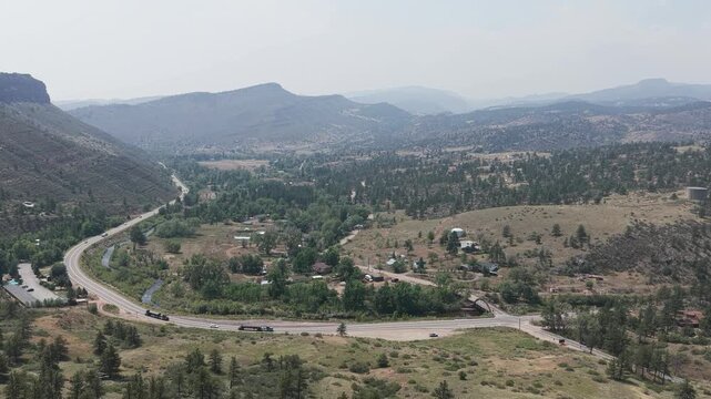 Aerial view of Spring Gulch featuring winding roads, dense pine forests, and rugged mountain terrain in Clear Creek County, Colorado, United States.