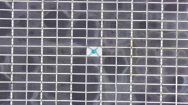 Aerial view of a solar panel array featuring a cleaning robot moving across the surface in Liabygda, More og Romsdal, Norway.