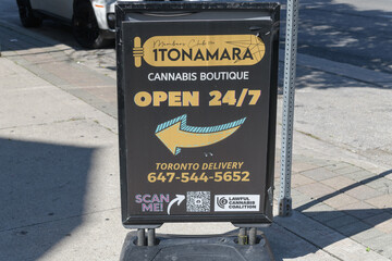 Fototapeta premium sidewalk sign outside 1Tonamara, a cannabis store, located at 202 Spadina Av, Toronto