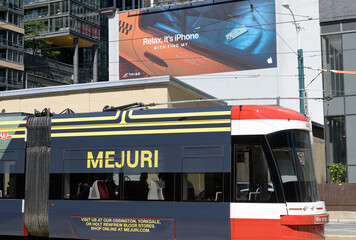 Fototapeta premium Toronto Spadina trolley with wrap advertising for Mejuri a jewelry company and Apple Inc wall info near King St W