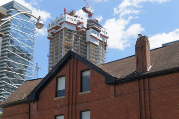 Fototapeta premium Theatre Park apartment building and FORMA Toronto Condos (Mirvish + Gehry) under construction contrasted with old building on John St