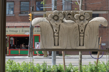 Fototapeta premium historic architectural carvings at Gallery Park at 129 McCaul St, Toronto (with defocused view of Village Idiot Pub)