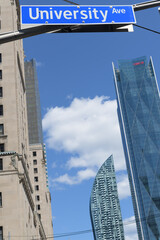 Fototapeta premium street sign at University Av where it intersects at Front St W with view looking east to Royal York hotel, L-Tower condo, and CIBC Square north towers, Toronto