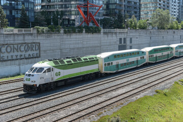 Fototapeta premium Go Trains arriving east bound on the Union Station Rail Corridor at Concord Cityplace (Spadina Av overpass), Toronto