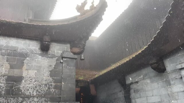 Rainy and foggy day at Kim Son Bao Thang Tu pagoda temple complex on top of Mount Fansipan in Sapa, Vietnam. Scenic view of traditional Vietnamese Buddhist architecture with stone walls
