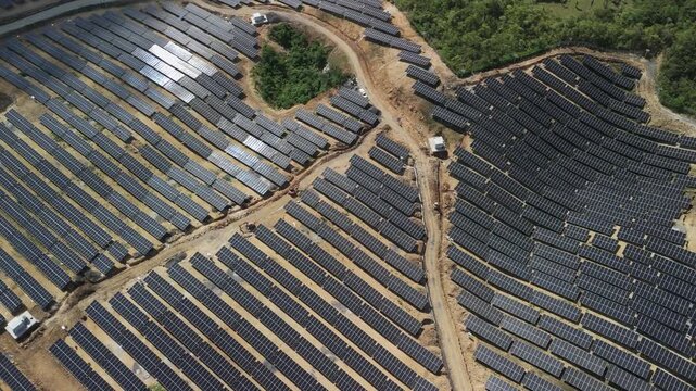 Aerial view of Sikatuna Solar Power Plant with rows of solar panels and dirt access paths in Sikatuna, Central Visayas, Philippines.