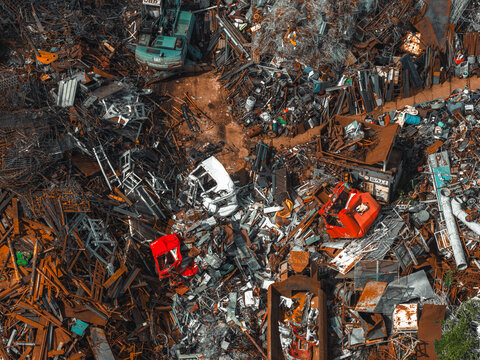 Aerial view of rusty steel scrap and discarded vehicles at a metal recycling yard in Poland.