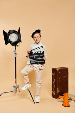 Little boy imagines being a film director while dressed in stylish cinematography attire
