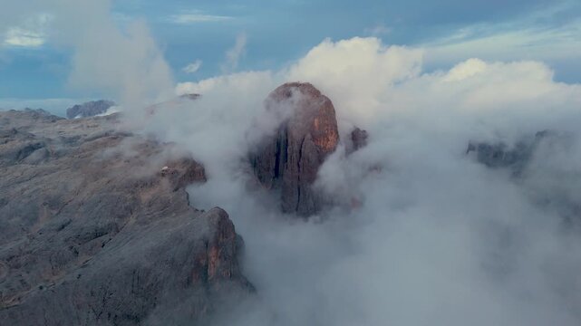 Aerial view of the jagged peaks of the Dolomites rising above a thick layer of clouds in San Martino di Castrozza, Trentino-Alto AdigeS, Italy.