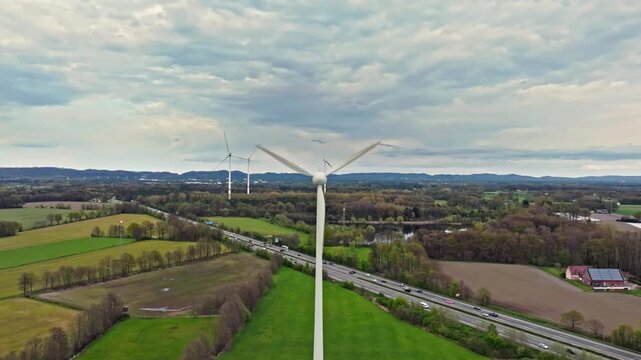 Windrad frontal mit Drohne aufgenommen. Wolkig und das Windraf dreht sich schnell. Erneuerbare Energien. Blick auf die Autobahn A2 von oben. D-Log-Originale vorhanden. Bei G&uuml;tersloh.