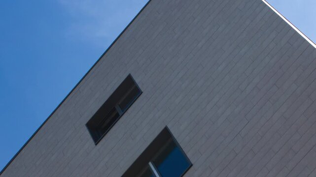 A modern architectural design featuring windows against the skyline. Glass windows on an office building, a business building, or a structure in the city. Minimalist architectural design, animation