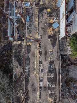 Aerial view of abandoned industrial ruins near Cape River, featuring weathered concrete foundations, rusted metal beams, and scattered debris in Charters Towers Regional, Queensland, Australia.