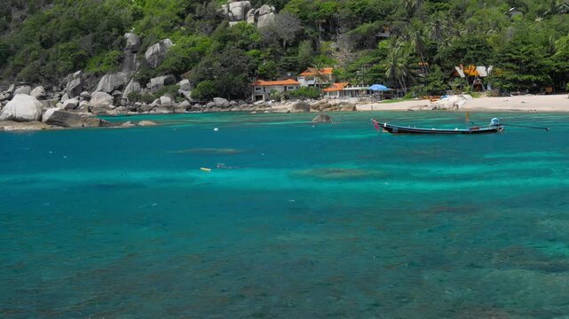 Tanote Bay on sunny day with rippled ocean water and longtail boat