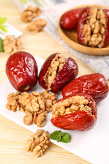 Fototapeta premium Xinjiang Jujube Dates Stuffed with Walnut Kernels - Healthy Traditional Chinese Snacks on Wooden Background