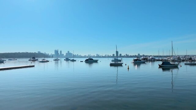 Aerial view of Matilda Bay with sailboats on calm water and Perth skyline in the distance, Crawley, Western Australia, Australia.