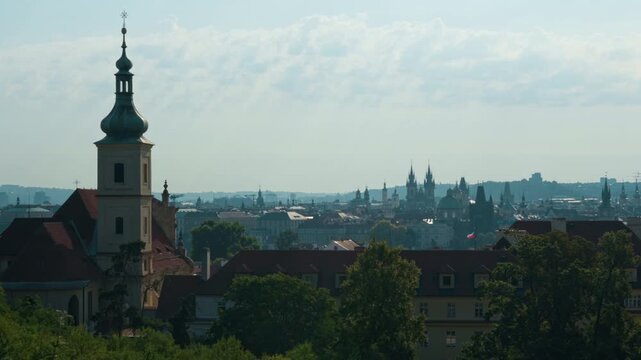 Historic Prague city skyline features iconic spires and towers in daylight. Traditional Czech architecture forms a famous European panorama. Cultural landmark represents travel heritage.
