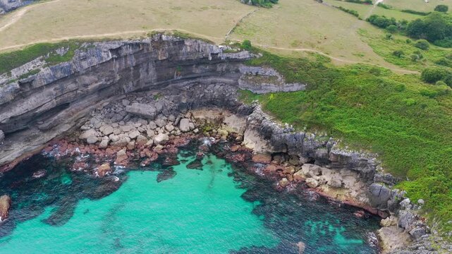 Aerial View of the Sea Cliffs and Green Grass Footpath Along Paseo de San Pedro Hiking Trail in Llanes, Asturias, Northern Spain