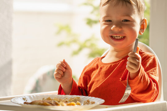 Smiling toddler having a healthy breakfast with homemade cottage cheese crepes.