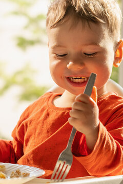 Cute little boy enjoying delicious crepes filled with cottage cheese at home.