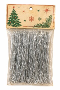 Christmas tinsel garland hanging on wooden gift box. Festive silver glitter decoration for holiday packaging and seasonal wrapping.