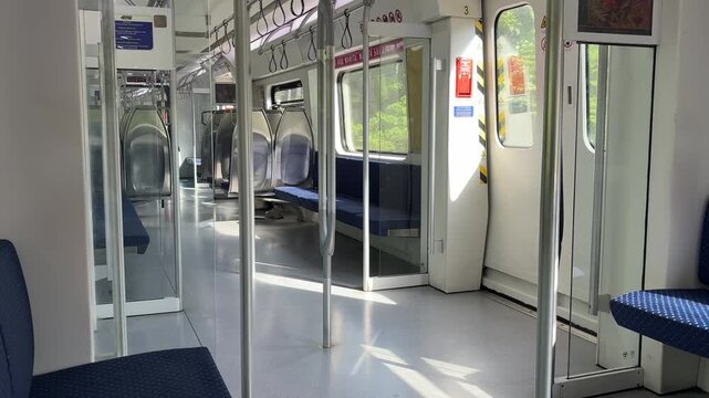 Malaysian KTM Komuter electric train arriving at the station platform, public transportation.