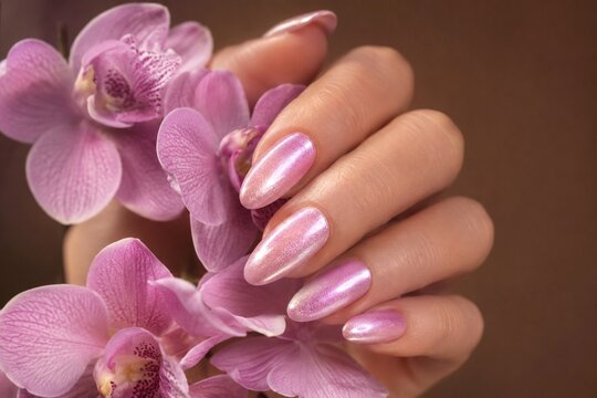 Pink manicure with orchid flowers for elegant beauty concept