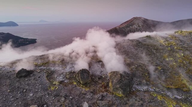 Dense volcanic smoke streams from fumaroles on rugged Vulcano island crater, Sicily, Italy, aerial view. The drone glides over sulfur deposits revealing breathtaking Aeolian Islands panorama