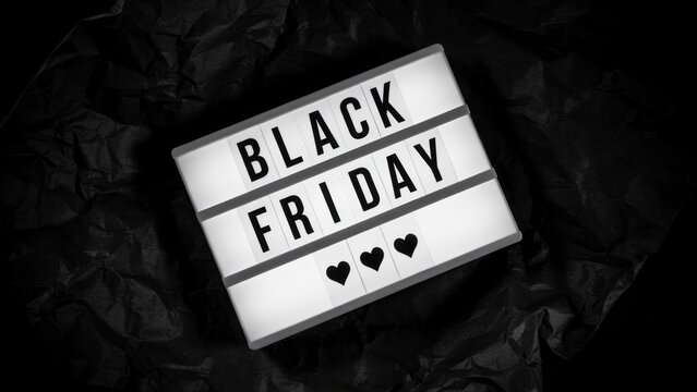 Black friday text on illuminated light box with three hearts