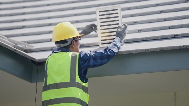 Technician wearing safety gear installs a solar panel system on a residential rooftop, representing renewable energy, sustainable housing, clean electricity, and home energy efficiency.