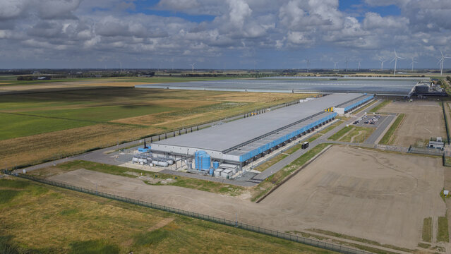 Aerial view of Google data center Agriport A7 surrounded by agricultural fields and wind turbines in Middenmeer, North Holland, Netherlands.