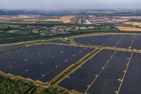 Aerial view of the large solar farm in the recultivated Leipziger Neuseenland area with rows of photovoltaic panels, coal mines and wind turbines in the distance Zwenkau, Saxony, Germany.