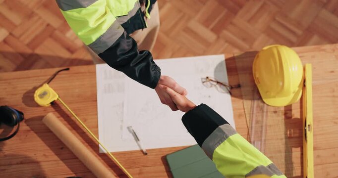Architect, people or blueprint with handshake for construction deal, agreement or onboarding. Top view, civil engineer or contractor shaking hands with layout plan for building project or partnership