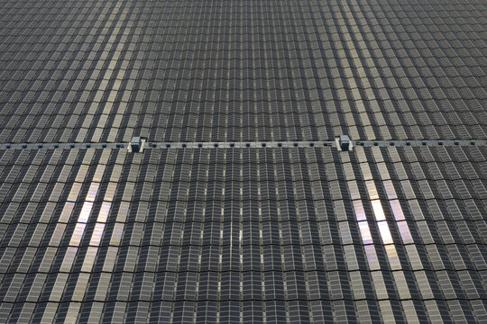Aerial view of a large solar panel array covering a rooftop with reflective glass panels in Zwolle, Netherlands.