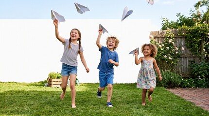 Obraz premium Childhood Dreams Take Flight: Three happy children joyfully launch paper airplanes into the sky on a sunny day in a grassy backyard, embodying the carefree spirit of youth.