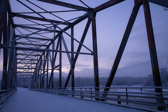 Old truss bridge in Palmer, Alaska after sunset in winter with blue purple glow in the sky