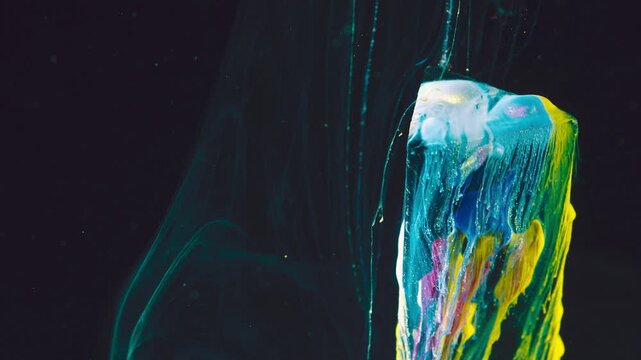 Glossy multicolor paint ribbons and drips descending against deep black background