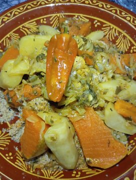 Traditional Moroccan couscous with steamed vegetables and tender meat in authentic clay dish