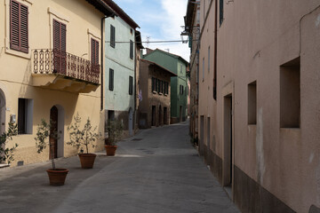 Fototapeta premium Picturesque narrow street with traditional pastel facades in the historic village of Castiglione d'Orcia, Tuscany, Italy
